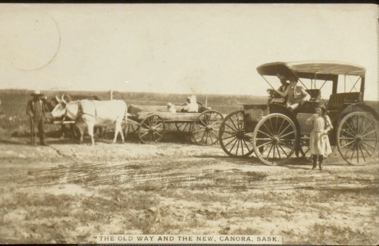 The old way and the new: ox-drawn wagon and an early automobile